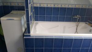 bagno piastrellato blu con vasca e servizi igienici di Berek Vendégház Fonyód a Fonyód Altre 32 foto