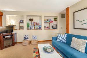 uma sala de estar com um sofá azul e uma televisão em Octopus Den em Coupeville
