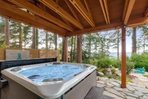 a hot tub on a patio with a wooden roof at Octopus Den in Coupeville