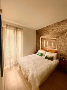 1 dormitorio con 1 cama grande y pared de ladrillo en Artist apartment centro storico, en Perugia