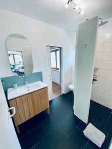 ein Bad mit einem Waschbecken und einem Spiegel in der Unterkunft Das Stubai - exklusiv, einzigartig & nachhaltig in Fulpmes