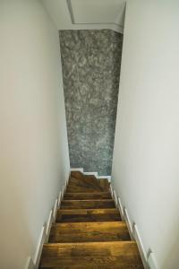 a staircase with wooden floors and a stone wall at beauty bar concept in Žilina