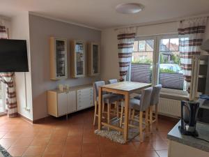 a dining room with a wooden table and chairs at Austernfischer Ferienwohnung in Dangast