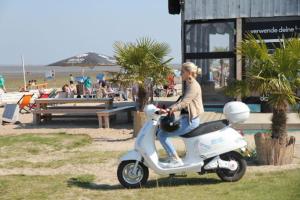 a young boy riding a scooter on the beach at Austernfischer Ferienwohnung in Dangast