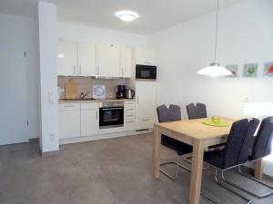 - une cuisine et une salle à manger avec une table et des chaises dans l'établissement Jadesand Nordsee Park Dangast, à Dangast