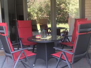 patio z czerwonymi krzesłami i stołem w obiekcie Kukshörn Nordsee Park Dangast w mieście Dangast