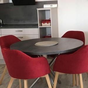 a dining room table with four red chairs around it at Strandliebe Nordsee Park Dangast in Dangast