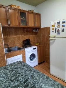 a kitchen with a white refrigerator and a washing machine at Sisi Guest House in Kutaisi
