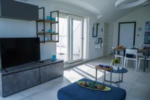 a living room with a flat screen tv and a table at NSM Blumarine Luxury home in Campomarino