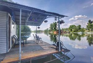 a dock with chairs and tables on a body of water at Splav Ljubavno Ostrvo in Čerević