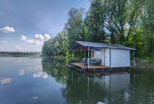 a small shack on a dock on a river at Splav Ljubavno Ostrvo in Čerević