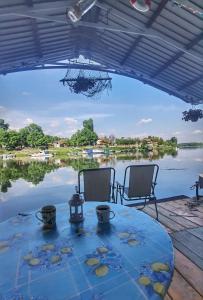 a table with two chairs and a view of a lake at Splav Ljubavno Ostrvo in Čerević