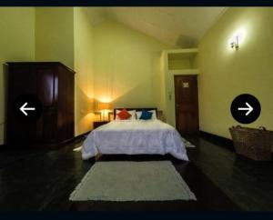 a bedroom with a bed with two arrows on the wall at Sherwood Bungalow in Bandarawela