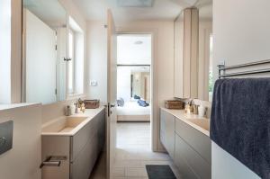 a bathroom with two sinks and a mirror at Magical Villa With Pool in Herzliya