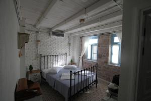 a bedroom with a large bed in a room with windows at Cesmeli Han in Ayvalık