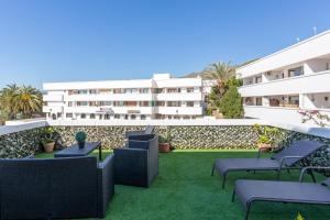 zewnętrzne patio z krzesłami i stołami w budynku w obiekcie Mariam Mojácar Apartment w mieście Mojácar
