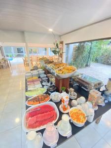 una línea de buffet con muchos tipos diferentes de comida en Caravaggio Praia Hotel, en Florianópolis