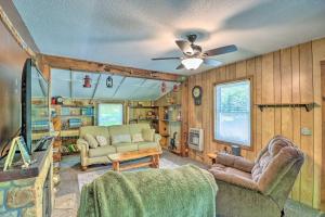 sala de estar con sofá y ventilador de techo en Charming Cabin in Mountain View with Deck!, en Mountain View