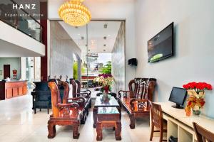 eine Lobby mit Stühlen, einem Tisch und einem Klavier in der Unterkunft HANZ Vuong Quang Hotel in Ho-Chi-Minh-Stadt
