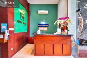 un bar dans un restaurant avec des fleurs au comptoir dans l'établissement HANZ Vuong Quang Hotel, à Hô-Chi-Minh-Ville