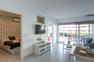 a bedroom with a bed and a living room with a tv at Mariam Mojácar Apartment in Mojácar