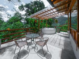 a patio with a table and chairs and a bath tub at Casa de Vista Alta in Mindo