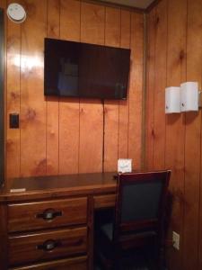 a room with a desk with a television and a chair at The Orca Inn in Friday Harbor
