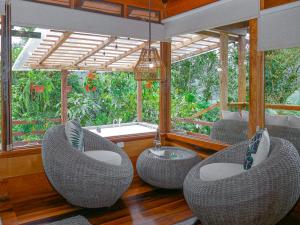 a room with wicker chairs and a sink and windows at Casa de Vista Alta in Mindo +79 photos