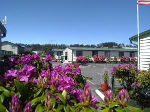 a parking lot with purple flowers in front of a motel at The Orca Inn in Friday Harbor