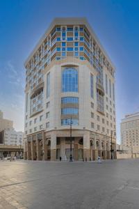 een groot kantoorgebouw met veel ramen bij Diwan Rose Hotel in Al Madinah