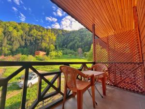 a table and chairs on a balcony with a view of a mountain at Kuzey Suite Otel in Uzungöl