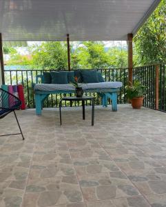 a patio with a blue bench and a table at Uvita Pirates Hostel in Uvita