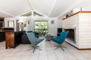 a living room with a fireplace and blue chairs at Care Villa T4 avec piscine in Moliets-et-Maa