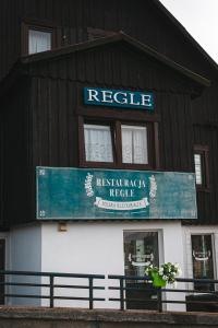 a building with a sign for a restaurant at Ośrodek Wypoczynkowy Regle in Zieleniec