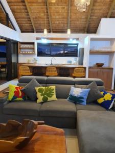 a living room with a gray couch with colorful pillows at Moorea Lodge Bungalow in Temae