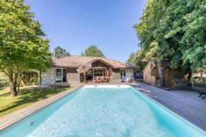 a house with a swimming pool in front of a house at Care Villa T4 avec piscine in Moliets-et-Maa