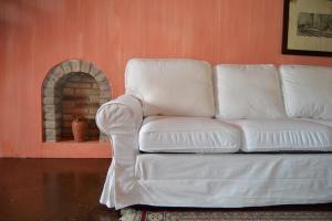 クレーマにあるB&B Il Torrazzoのリビングルーム(暖炉付)の白いソファ