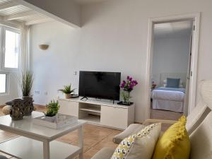 sala de estar con sofá y TV en Apartamento Las Tabaibas, en Puerto del Carmen