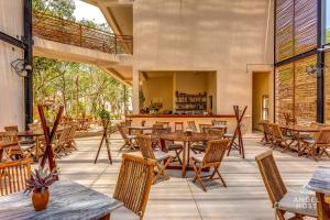 un patio extérieur avec des tables et des chaises en bois dans l'établissement Nature Luxury Selva Norte, à Tulum