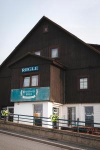 a building with a sign on the side of it at Ośrodek Wypoczynkowy Regle in Zieleniec