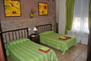 Habitación con 2 camas con sábanas verdes en Casa Rural Landa, en Galbarra