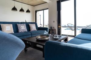 a living room with blue couches and a coffee table at amara luxury villas in Lachania
