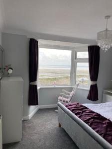 Un dormitorio con una cama y una ventana grande. en fabulous sea views and sunsets, en Morecambe 17 fotos más