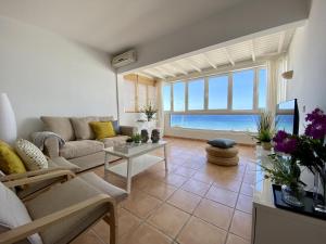sala de estar con sofá y vistas al océano en Apartamento Las Tabaibas, en Puerto del Carmen