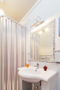 a bathroom with a sink and a mirror at Caio Asinio Apartment in Naples