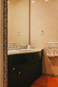 a bathroom with a sink and a mirror at Casa das Pipas / Quinta do Portal in Sabrosa