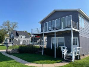 a house with a balcony and two white chairs at 3 Bedroom Condo with Lake Pepin views with access to shared outdoor pool in Lake City