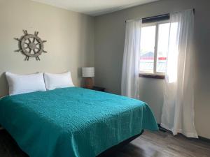 Un dormitorio con una cama verde y una ventana en 3 Bedroom Condo with Lake Pepin views with access to shared outdoor pool en Lake City