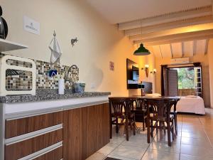 eine Küche und ein Esszimmer mit einem Tisch und Stühlen in der Unterkunft Delphin Apartamento 8 in Ilhabela