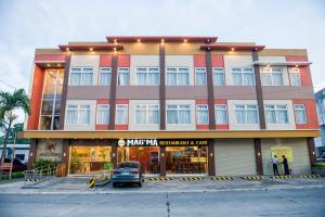 a building with a car parked in front of it at HOTEL HERENCIA 625 formerly Abaca Suites in Daraga